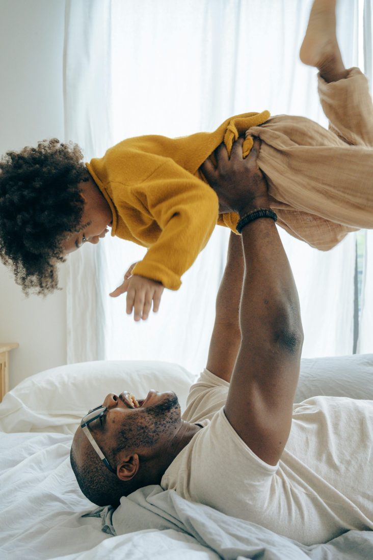 A parent lifting a laughing child in the air
